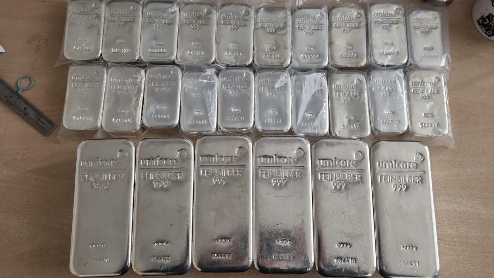 Rows of fine silver 999 bullion bars laid out on a table